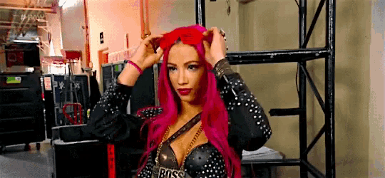 a woman with red hair is wearing a black and gold outfit and a red headband .