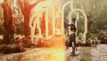 a woman in a costume is standing in the middle of a forest with a fireball coming out of her hands .