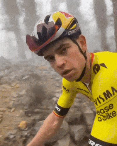 a man wearing a helmet and a yellow shirt that says visma on it