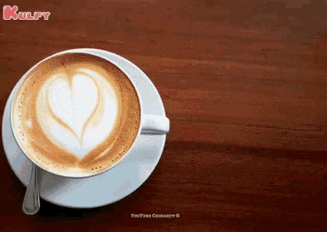 a cup of cappuccino on a saucer with a heart shaped foam