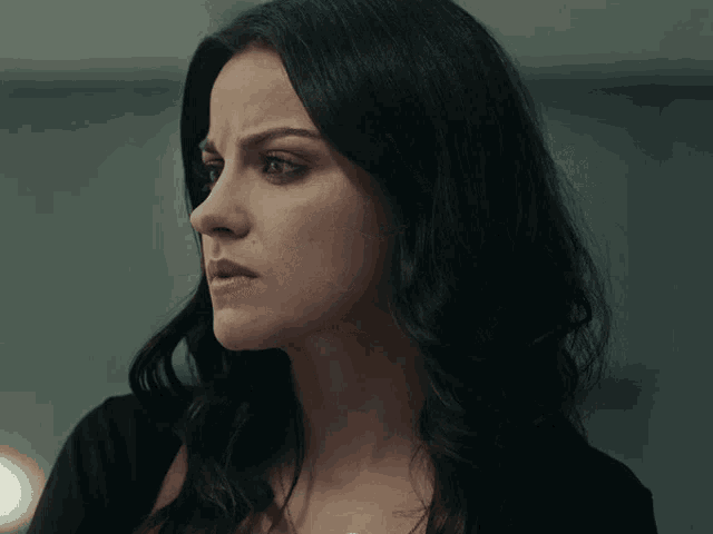 a close up of a woman 's face with a serious expression