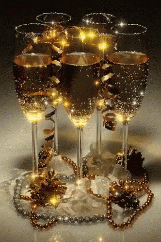 a display of wine glasses with gold ribbons and beads
