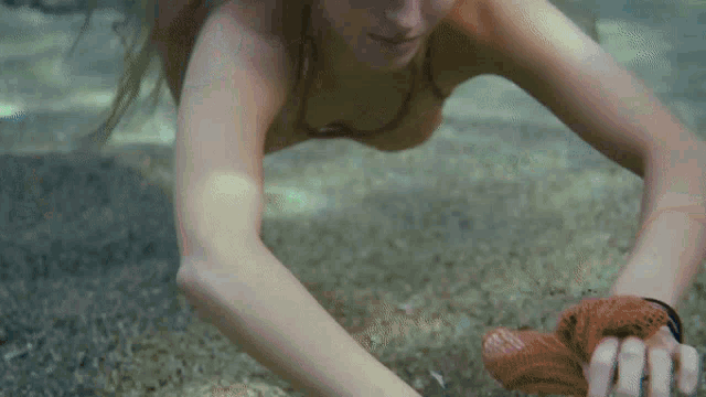 a woman in a bikini is crawling in the sand