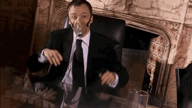 a man in a suit and tie wears an oxygen mask