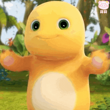 a yellow stuffed animal with green eyes is standing in the grass with its arms outstretched