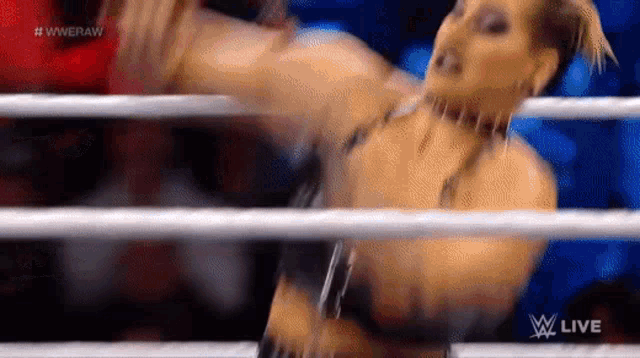 a woman is standing in a wrestling ring with a microphone in her hand .