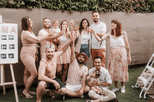 a group of people toasting in front of a sign that says mama