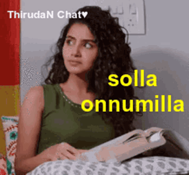 a woman in a green tank top is sitting on a couch reading a book