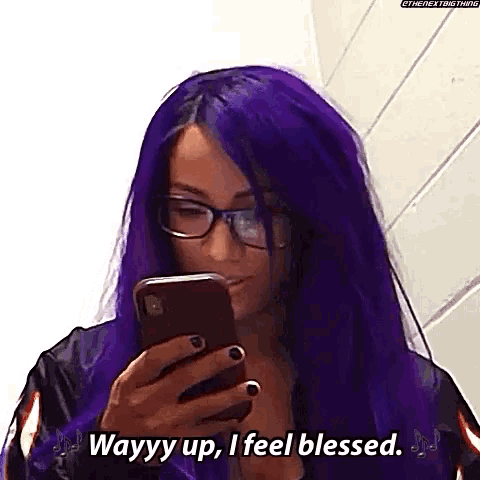 a woman with purple hair and glasses is looking at her cell phone and saying `` wayyy up , i feel blessed ''