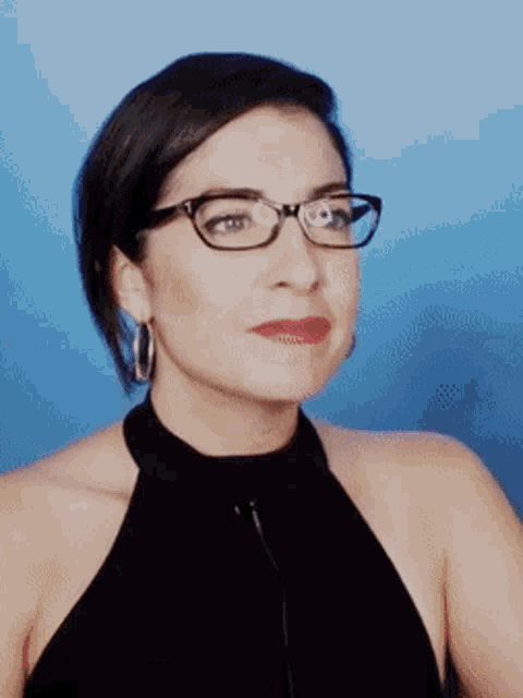 a woman wearing glasses and a black halter top
