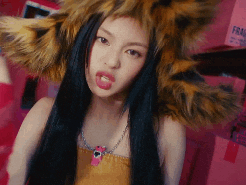 the woman is wearing a fur hat and a necklace .