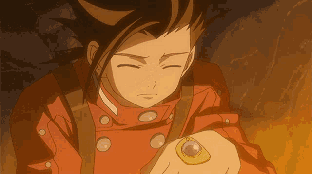 a boy in a red jacket is holding a watch on his wrist