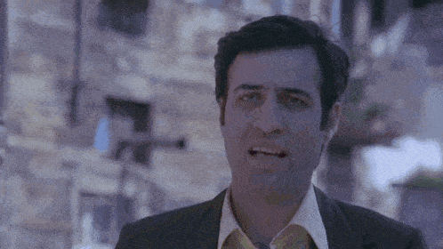 a man in a suit and tie making a funny face