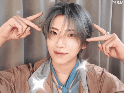 a young man with gray hair making a peace sign with his hands