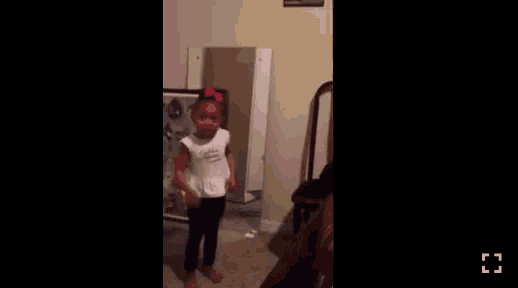 a little girl is standing in front of a mirror in a room ..
