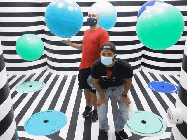 a man wearing a mask stands next to another man