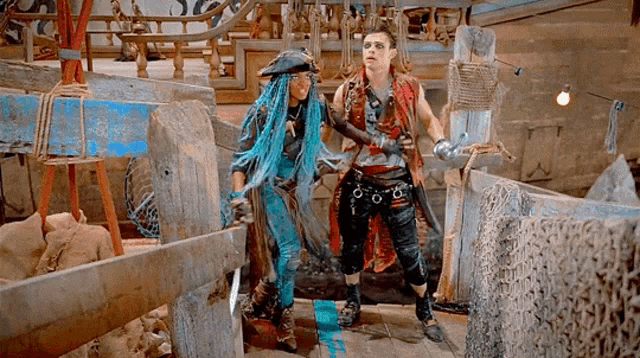 a man and a woman in pirate costumes are standing next to each other in a room .