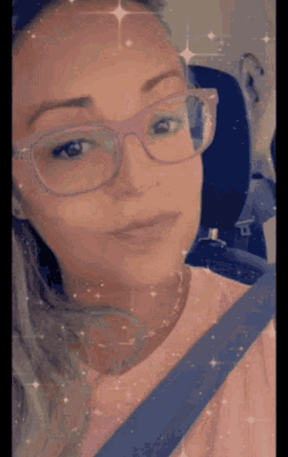 a woman wearing purple glasses and a pink shirt