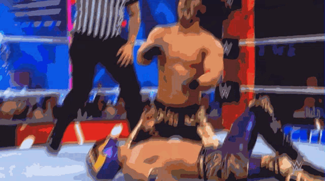 a wrestling match with a referee and a w logo on the ring