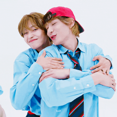 two boys hugging each other with one wearing a blue shirt with blue written on it