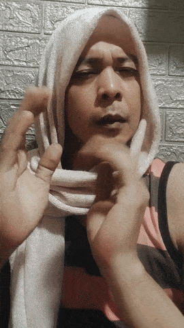 a man wearing a scarf around his head looks at the camera