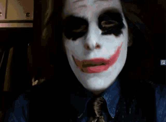 a man with his face painted like the joker is wearing a tie