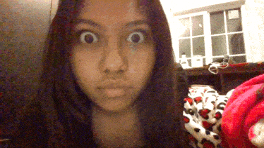 a girl making a funny face with a leopard print blanket in the background