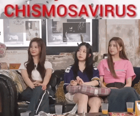 three girls are sitting on a couch with a sign that says chismosaurus in the background .