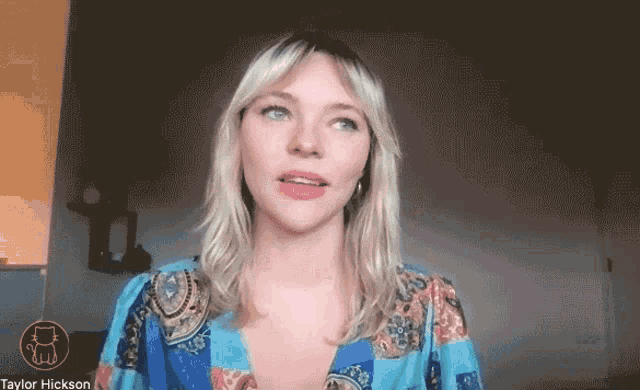 a woman with blonde hair is wearing a blue shirt and has the name taylor hickson at the bottom