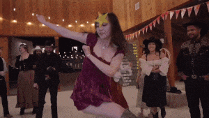 a woman in a red dress with a star on her head is dancing