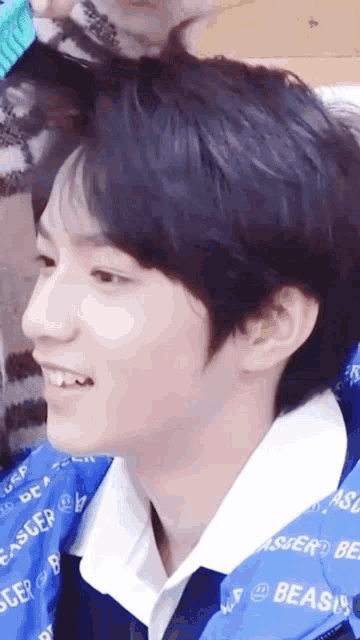 a close up of a person wearing a blue jacket with the word beast on it
