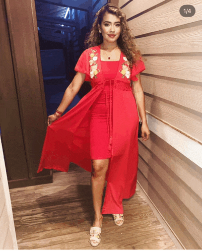 a woman in a red dress is standing in front of a wall with the number 1/4 on the bottom left