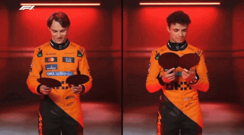 a man in a mclaren uniform is holding a black object in front of his face