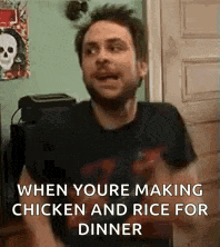 a man is making chicken and rice for dinner while wearing a black shirt .