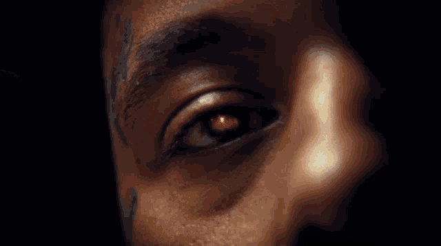 a close up of a man 's face with a white shirt on