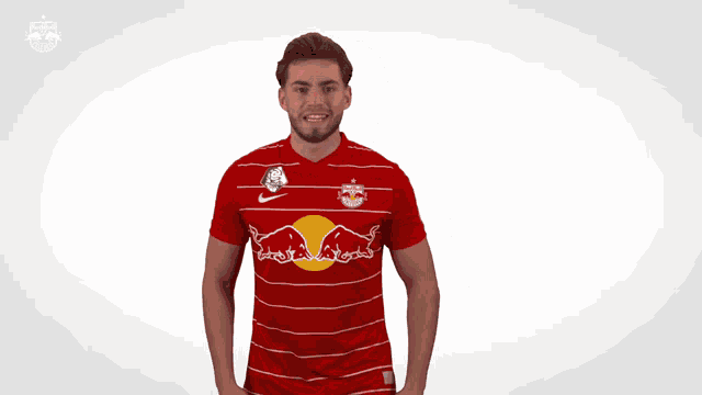 a man is wearing a red and white striped shirt with a red bull on it