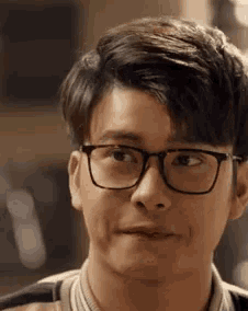 a close up of a young man wearing glasses