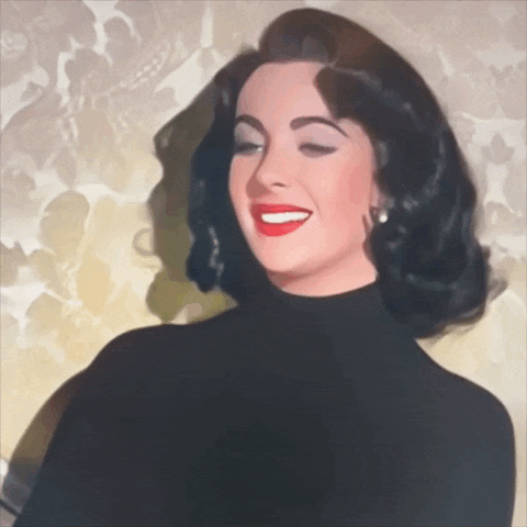 a woman in a black turtleneck is smiling with her eyes closed