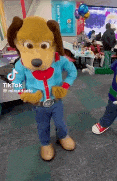 a dog mascot is standing in front of a table with balloons and a sign that says tik tok