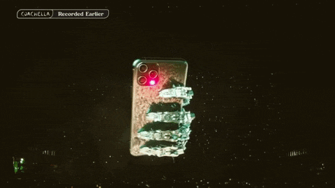 a cell phone with a red light on it is being held up by a robot