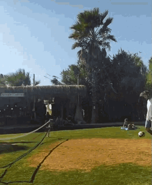 a man is kicking a soccer ball in front of a sign that says corner hotel