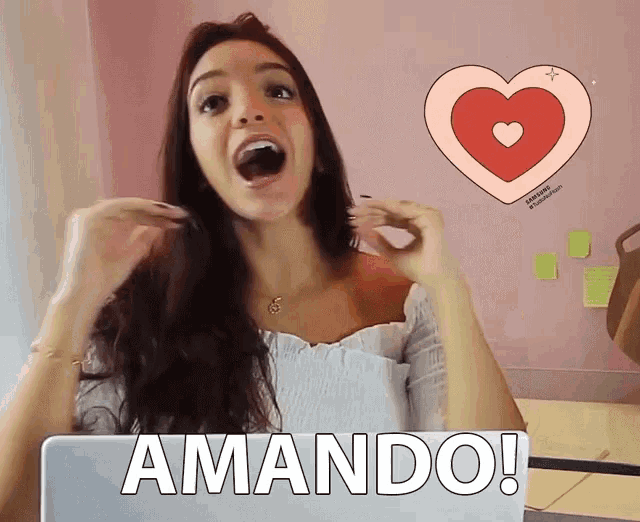 a woman sitting in front of a laptop with the word amando on the screen