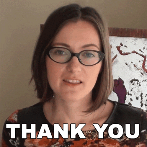 a woman wearing glasses says thank you in front of a picture