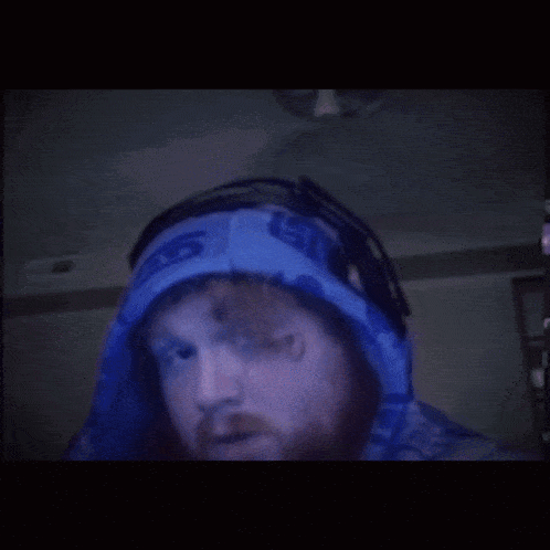 a man with a beard wears a blue hoodie