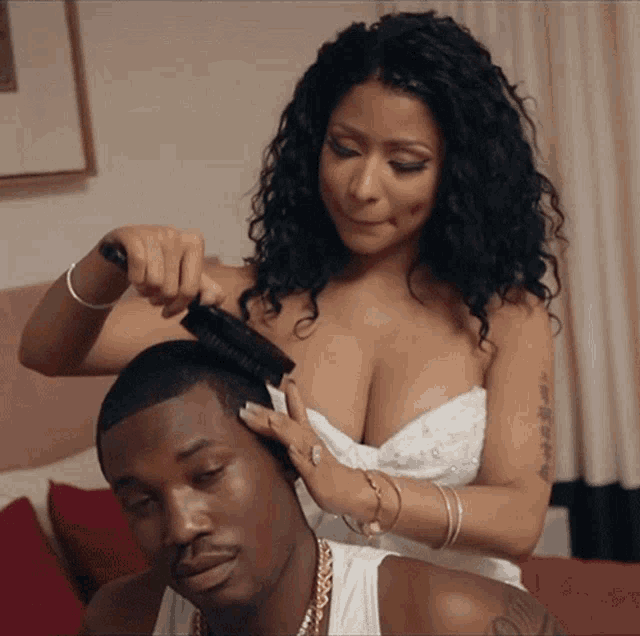 a woman brushes a man 's hair with a brush