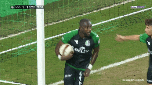 a soccer player in a green shirt that says bmley on it