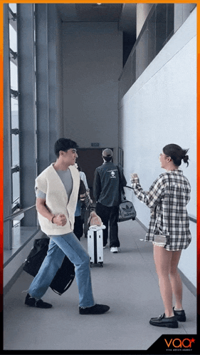 a man and a woman are walking down a hallway and the word voor is on the bottom