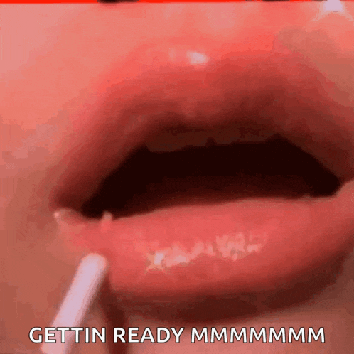 a close up of a person applying lip gloss with the words gettin ready written below it