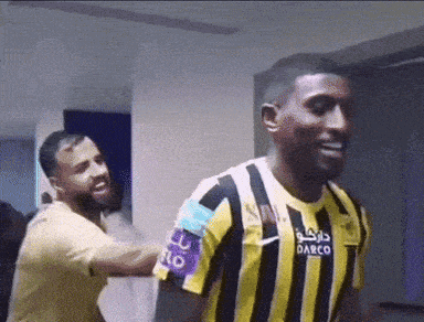 a man wearing a yellow and black striped shirt that says darco on it