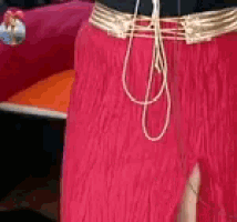 a person is wearing a pair of red fringed pants with a white belt .